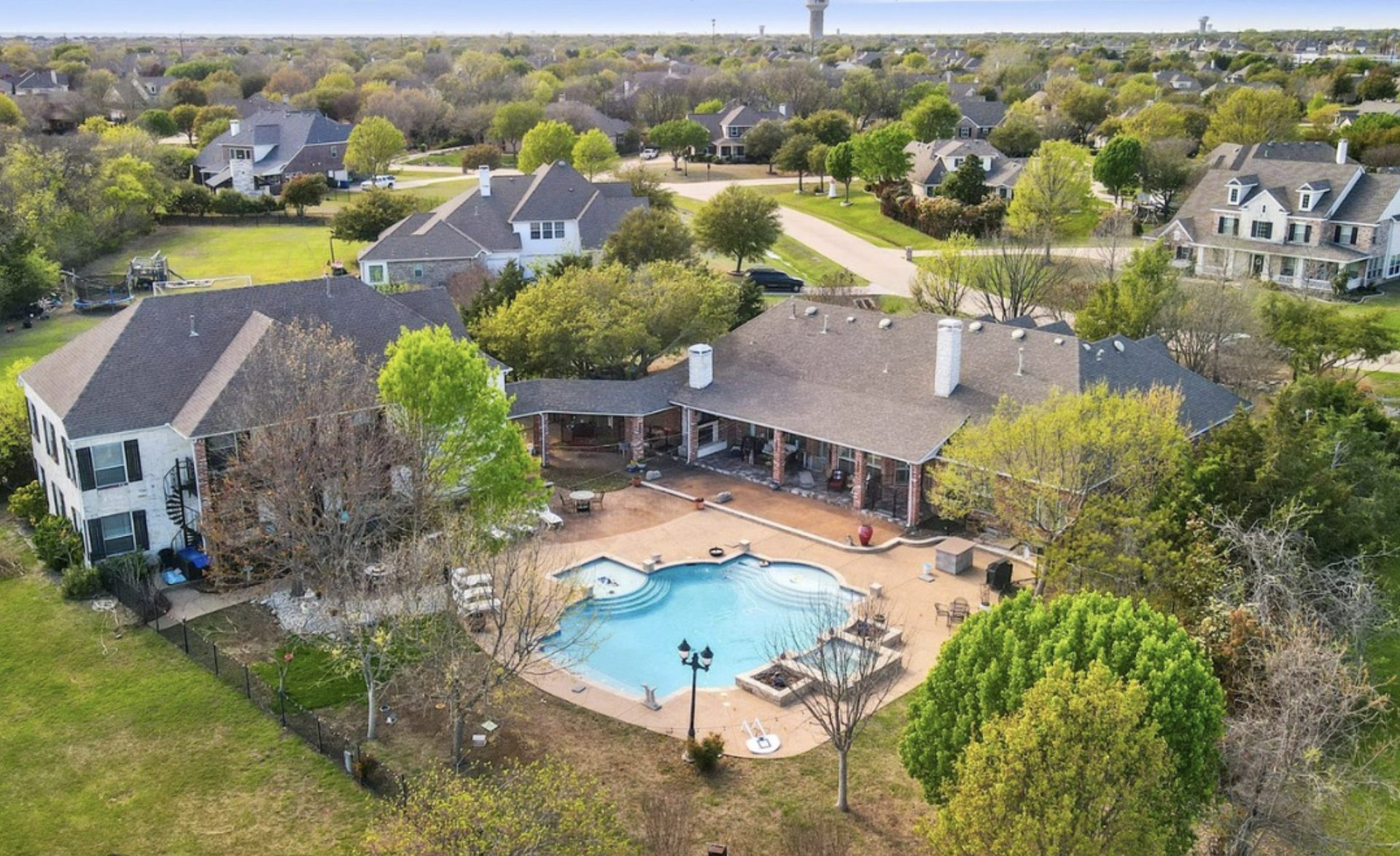 A backyard pool and a street of homes from the air, one of Paul Ruth's listings