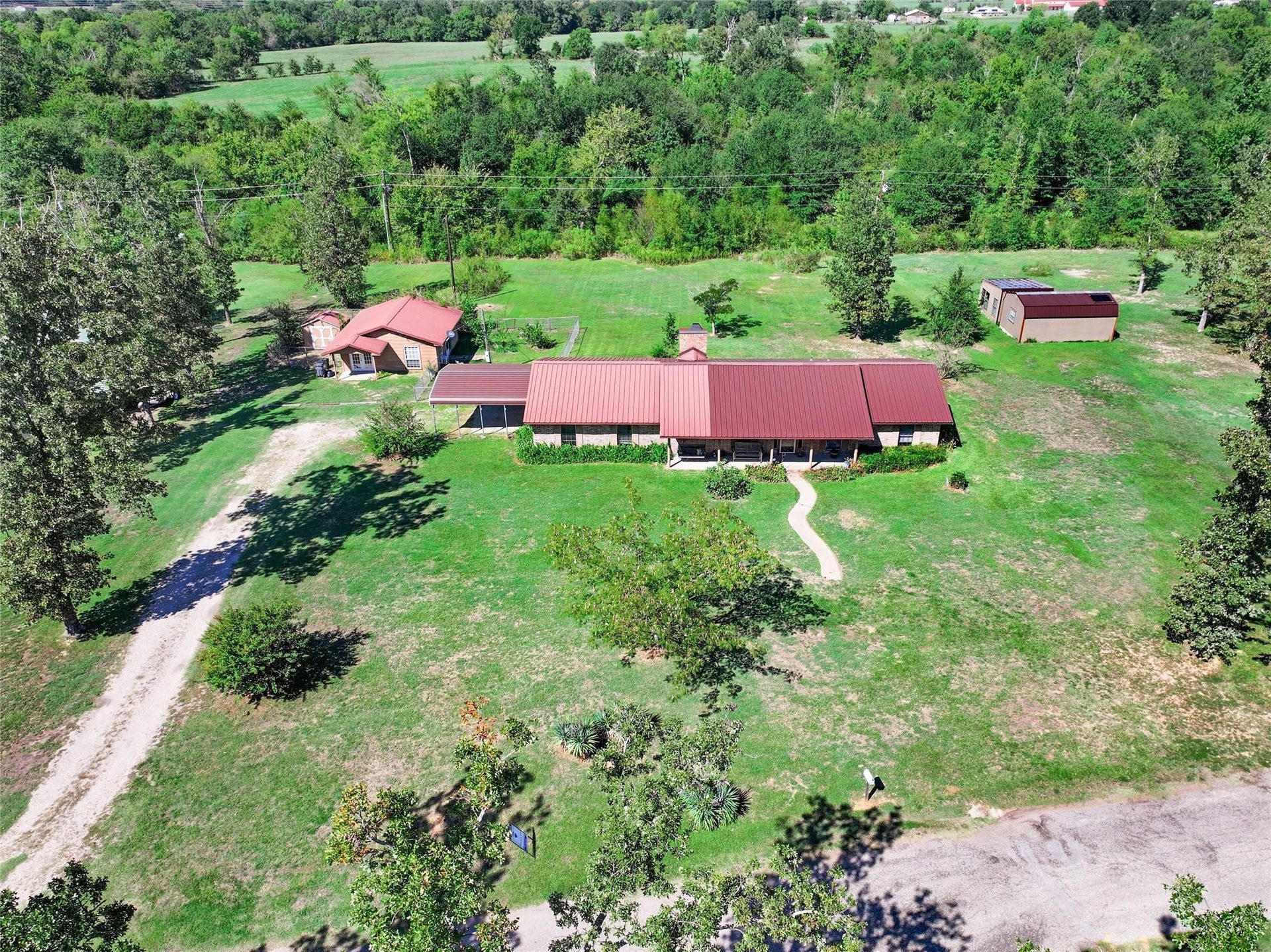 A ranch house with a red roof on acreage, from the air, one of Paul Ruth's listings